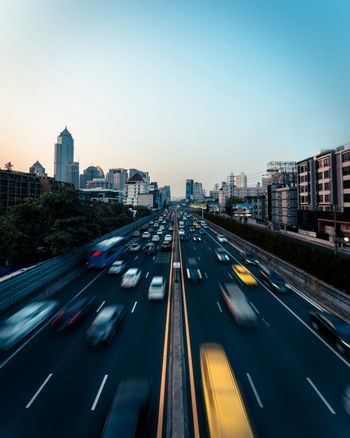 cars on road near city buildings during daytime