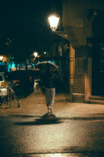 a person walking down a street holding an umbrella