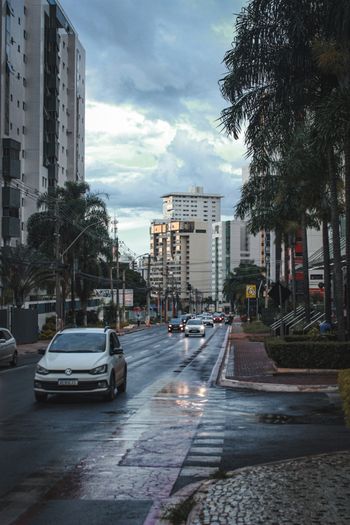 a city street filled with lots of traffic next to tall buildings