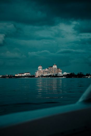 city skyline near body of water under cloudy sky during night time