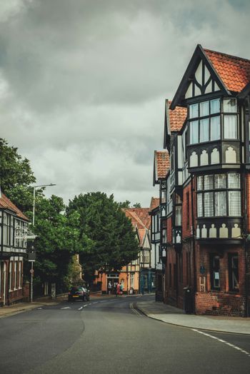 a street lined with tall buildings under a cloudy sky