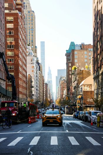 a yellow sports car driving down a city street