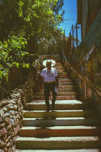 A man with a sombrero walking down a set of stairs