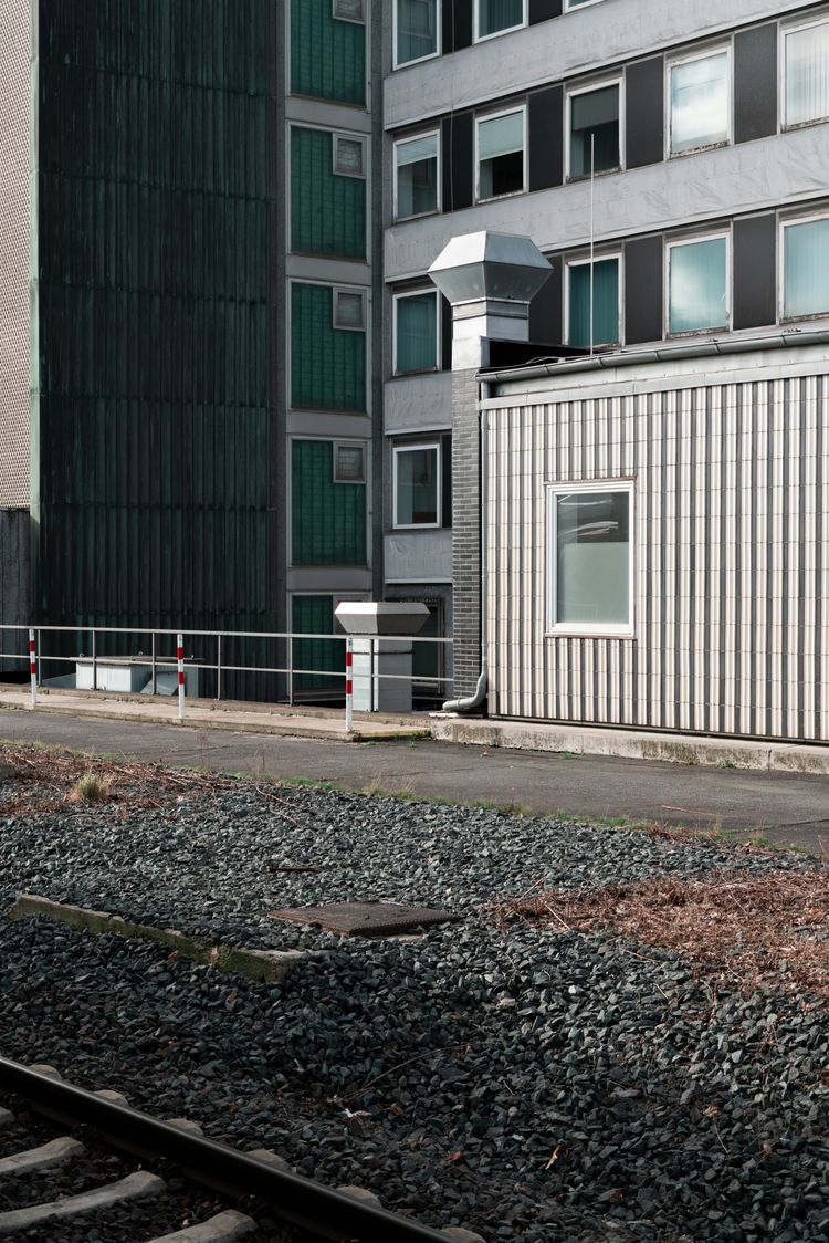 a train track next to a tall building