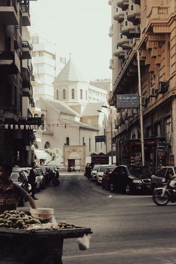 a person sitting at a table in the middle of a street