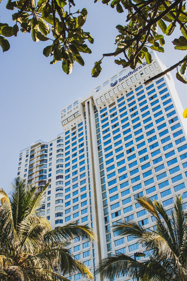 a tall white building with palm trees in front of it