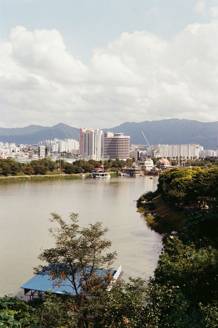 city skyline near body of water under white cloudy sky during daytime