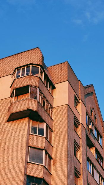 a tall brick building with windows and balconies