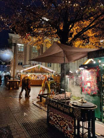 a person walking down a street next to a food stand