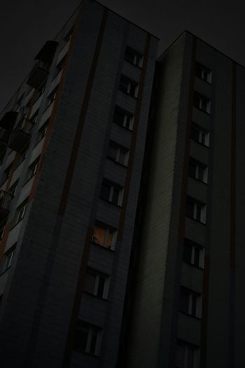 a tall building with two windows at night