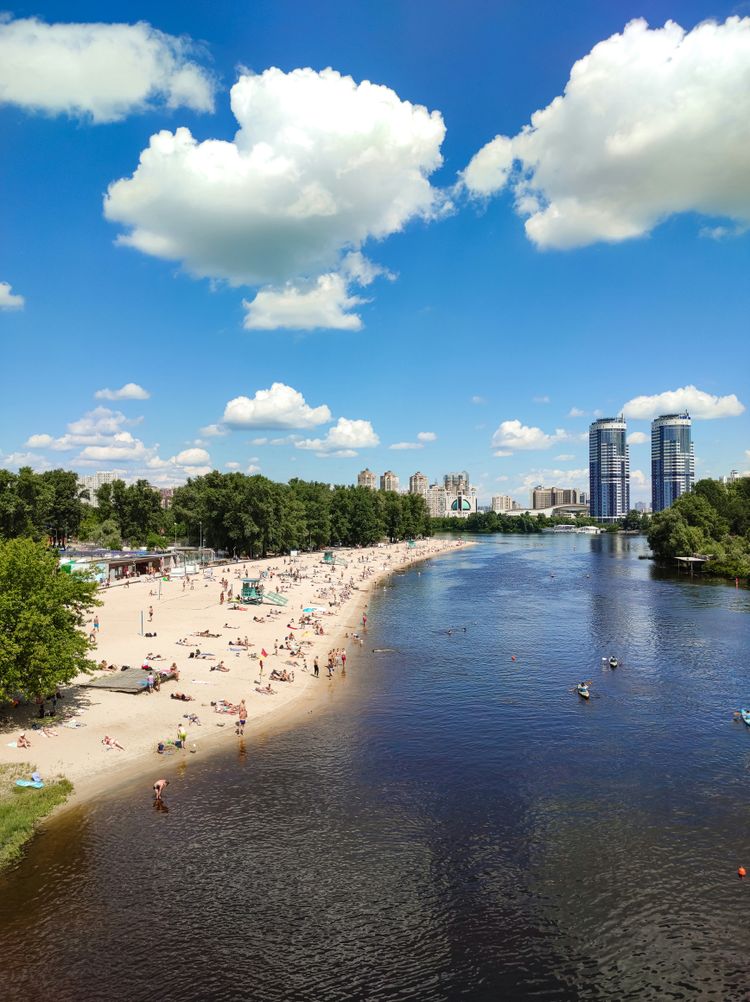 a body of water surrounded by trees and people