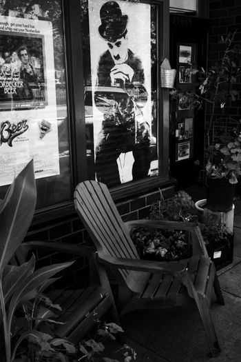 A black and white photo of a chair and a poster