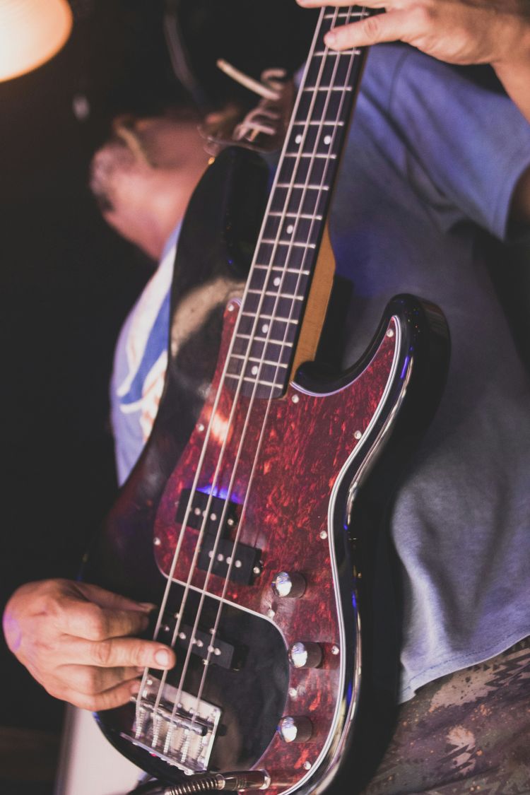 a person holding a bass guitar in their hand