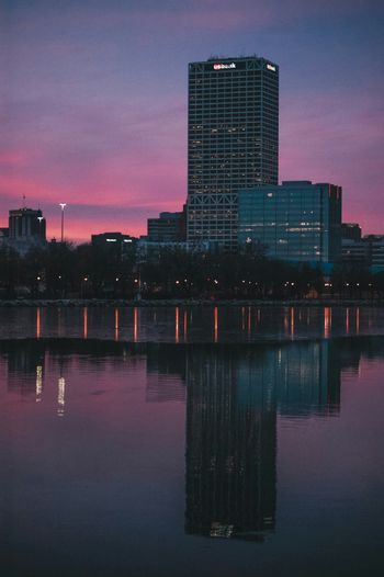 a city skyline is reflected in a body of water