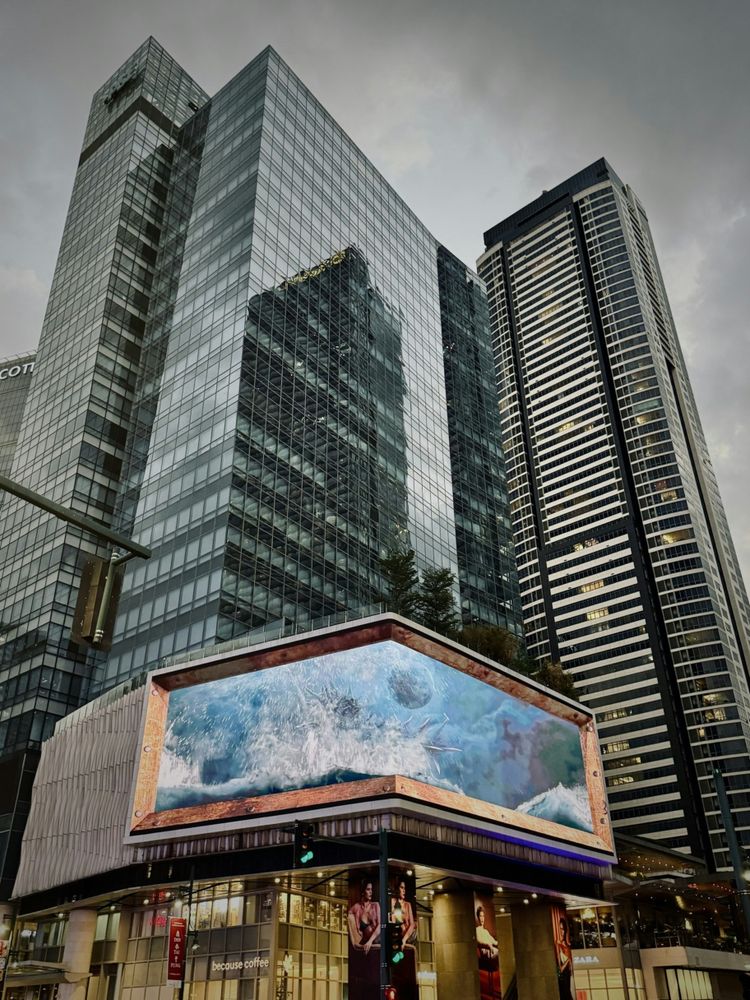 two people standing in front of a large billboard