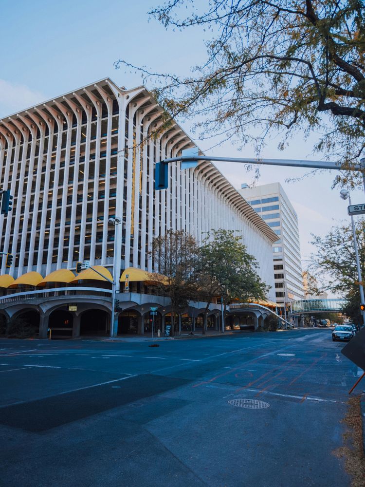 A tall white building sitting on the side of a road