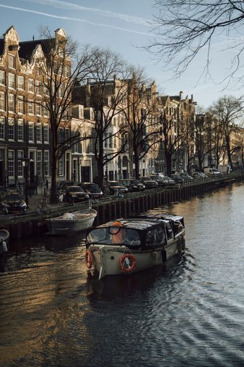 a boat traveling down a river next to tall buildings