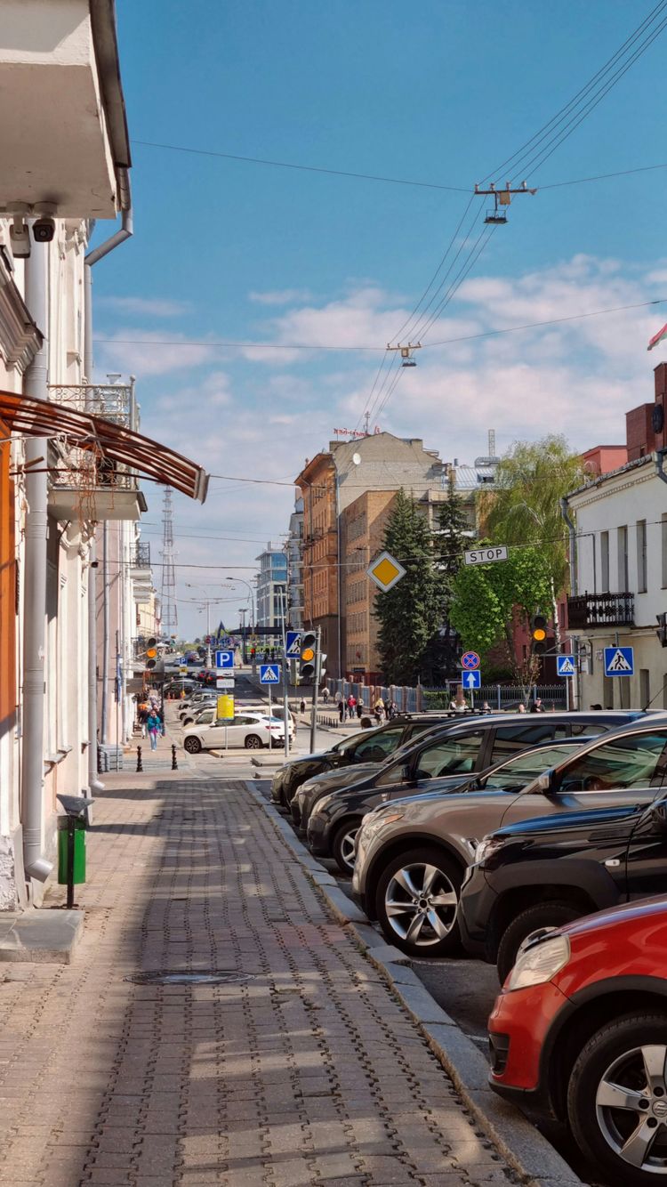 a row of parked cars sitting on the side of a road