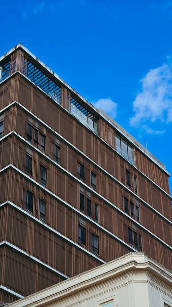 A tall brown building with lots of windows