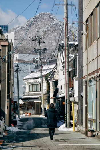 a person walking down a street with a mountain in the background