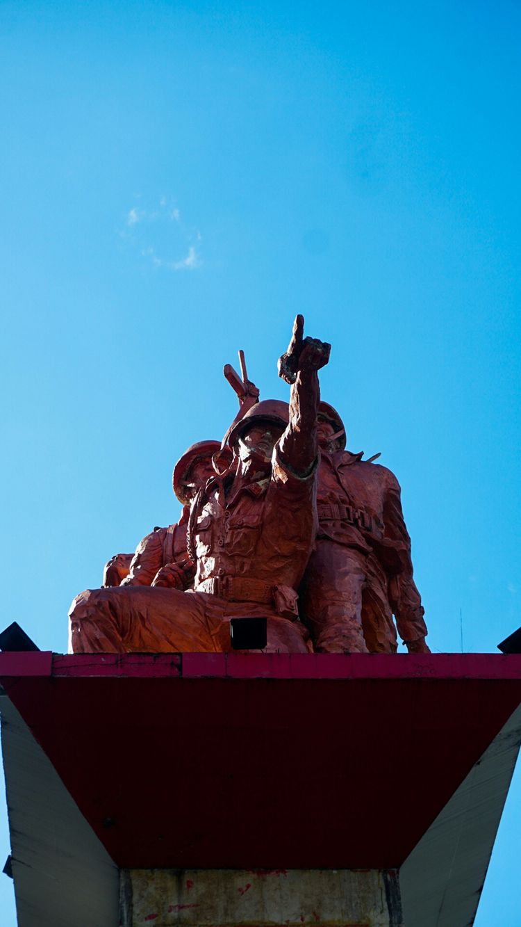 A clock tower with a statue on top of it