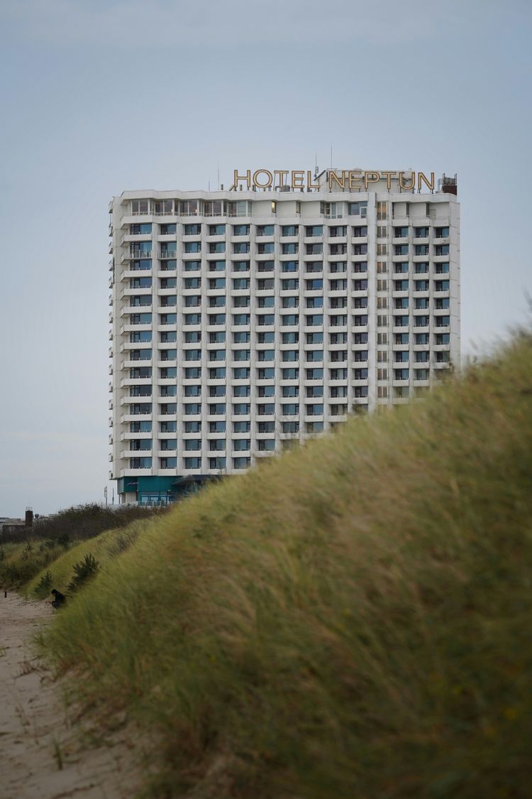 a tall white building sitting on top of a sandy beach