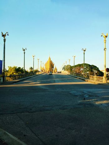 an empty street with street lamps on either side