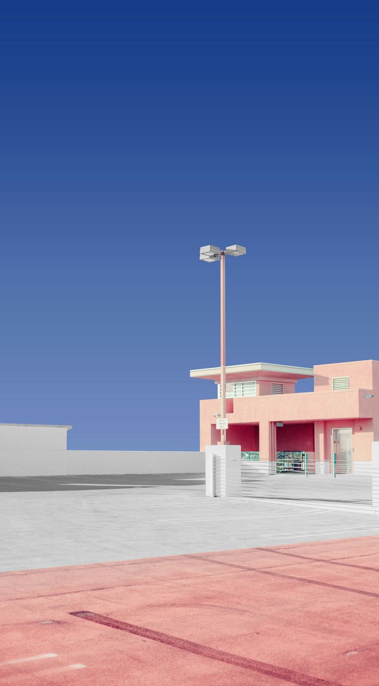 a pink building with a parking lot in front of it