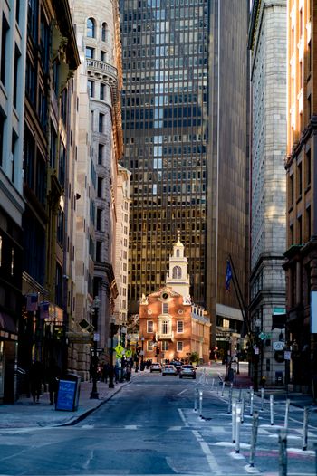 a city street with tall buildings and a clock tower