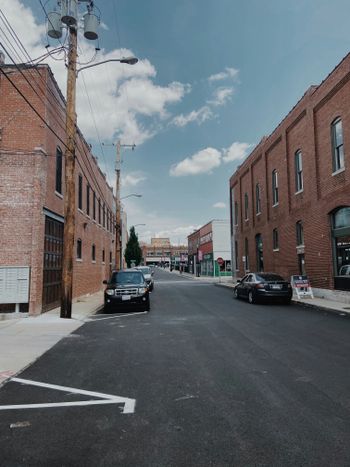 black car parked beside brown concrete building during daytime