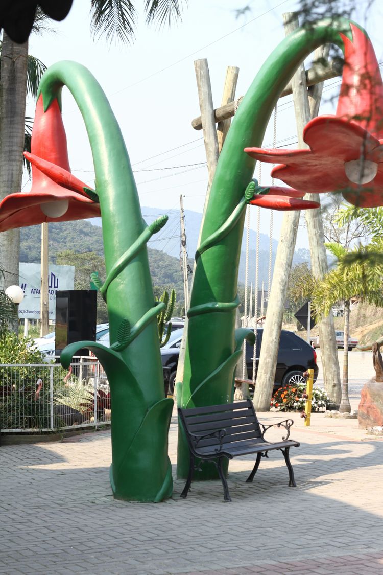 A bench sitting in front of a tall sculpture