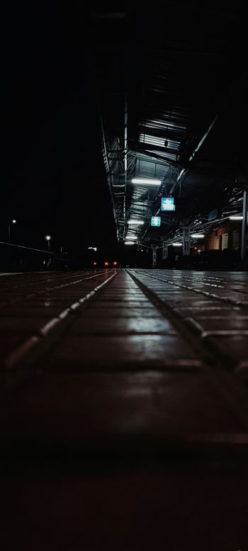 A black and white photo of a walkway at night
