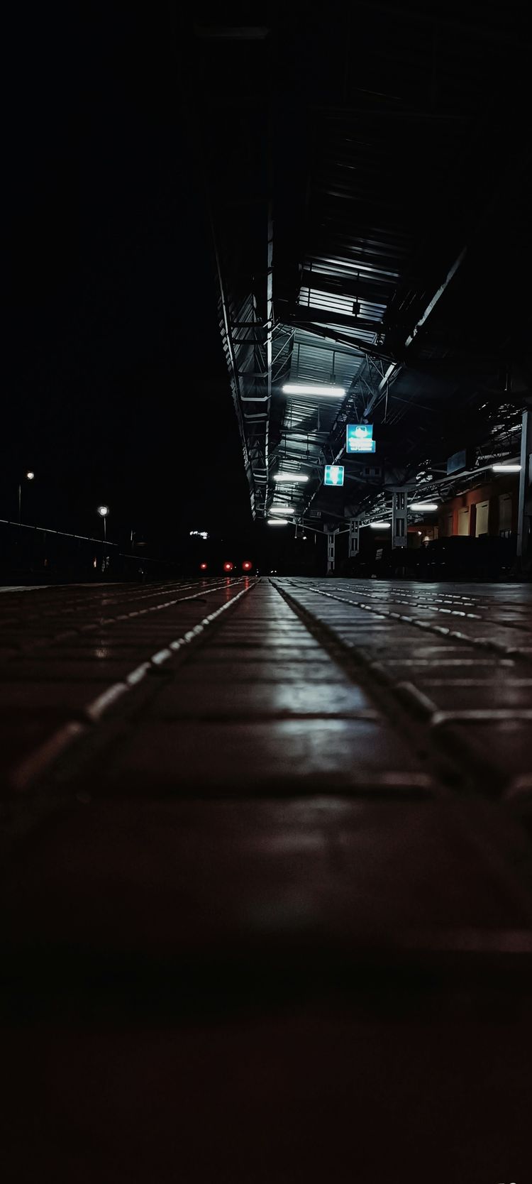 A black and white photo of a walkway at night