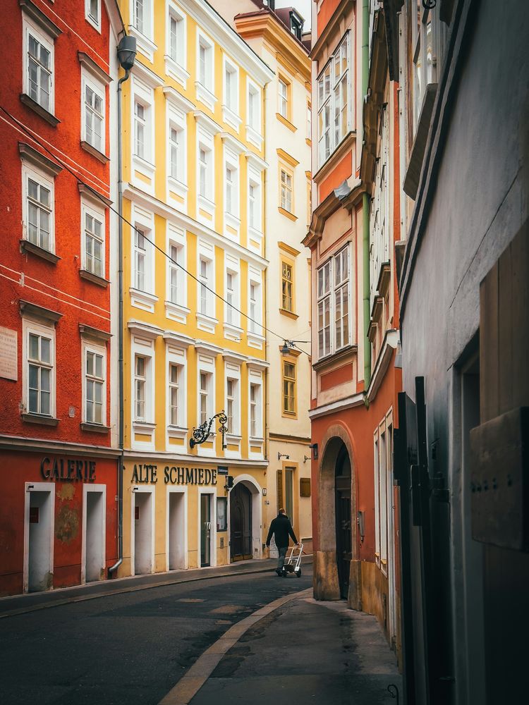 a narrow street in a european city with tall buildings