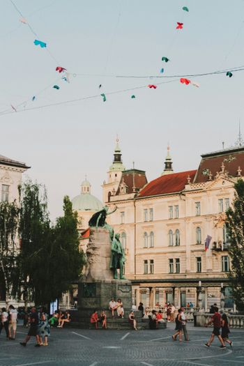 a group of people walking around a city square