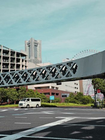 A large metal bridge over a street next to tall buildings