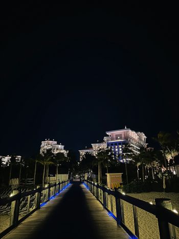 a walkway leading to a hotel at night