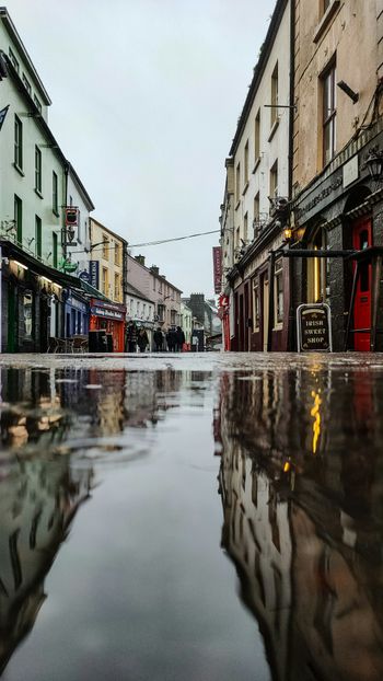 a city street with a puddle of water on the ground