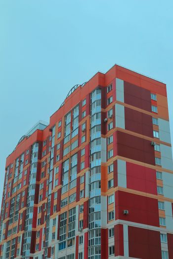 a tall red and white building next to a parking lot