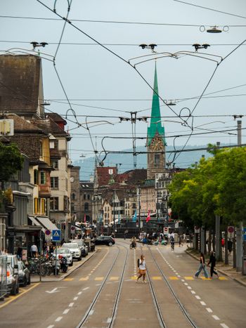 a view of a city street with a church steeple in the background