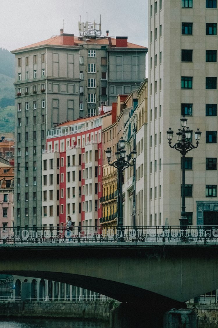 a bridge over a body of water with buildings in the background