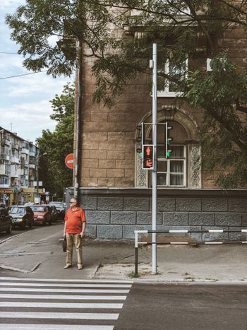 man standing on sidewalk near pedestrian lane