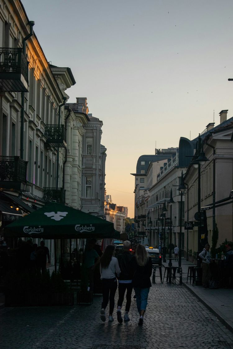 people walking on street near white concrete building during daytime