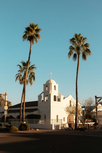 a white church with palm trees in front of it