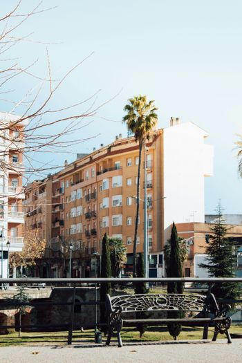 a park bench sitting in front of a tall building