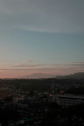 a view of a city at sunset from a hill