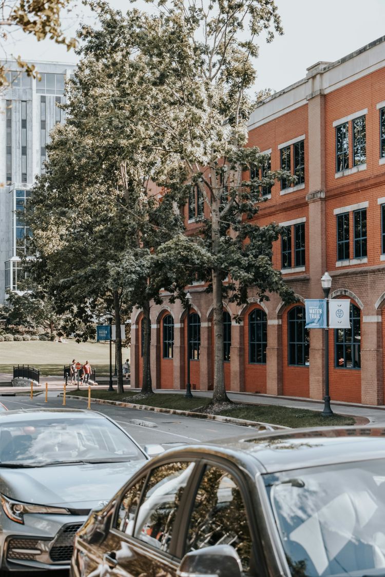 a car parked on the side of a street next to a tall building