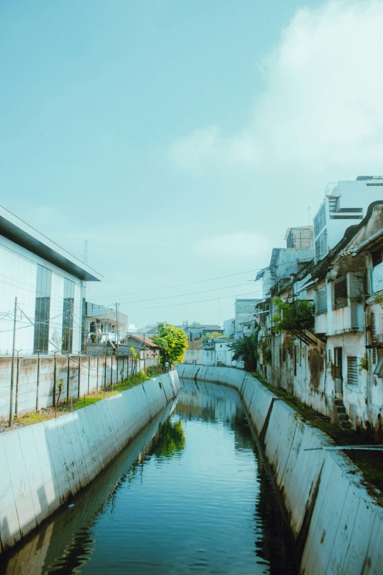 white concrete building beside river during daytime