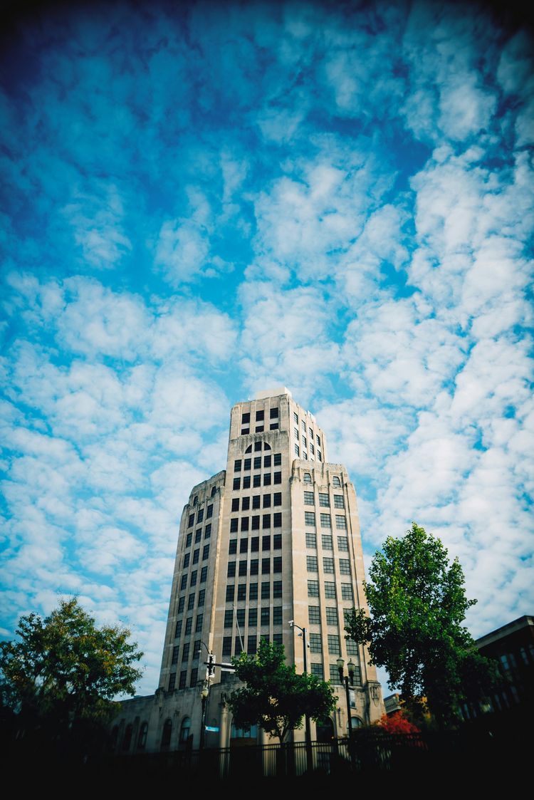 a very tall building sitting under a cloudy blue sky