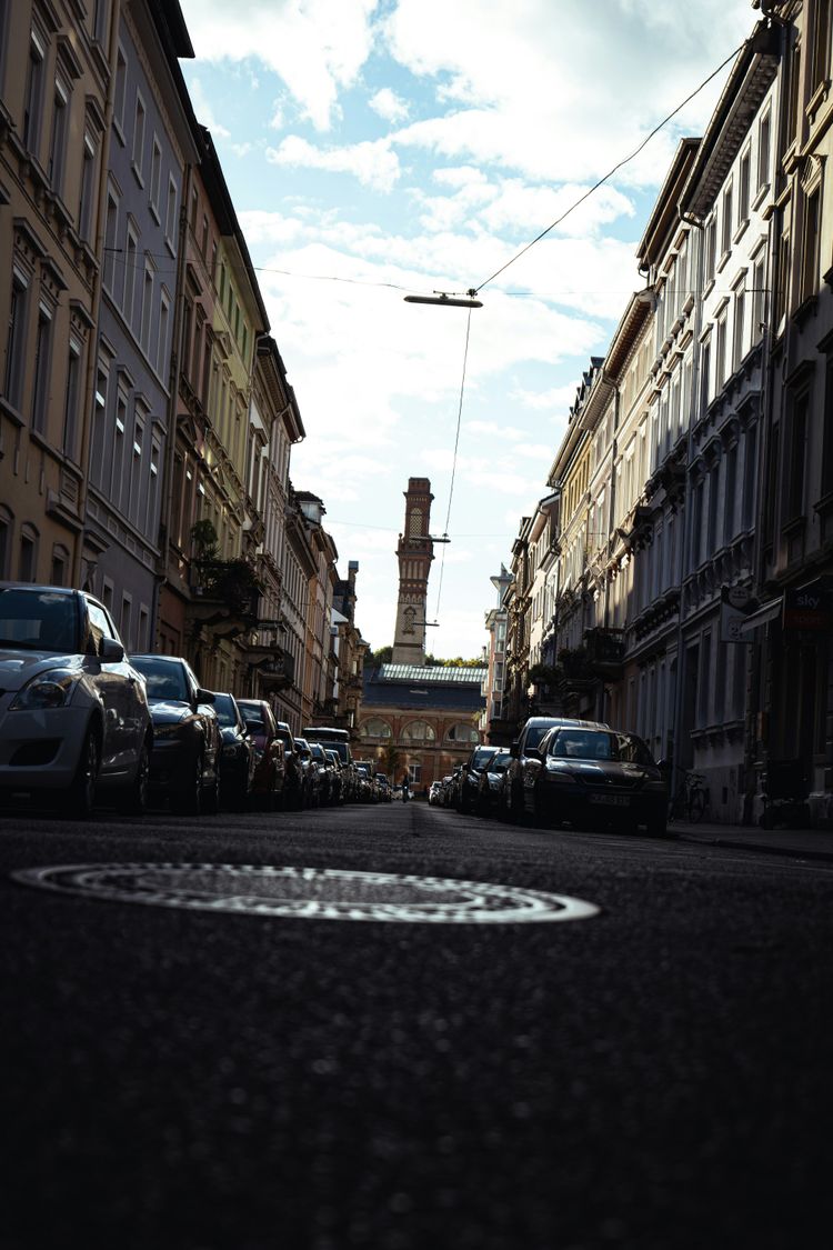 a street with cars parked on the side and buildings on the side